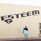 man holding surfboard outside Esteem Surf Co